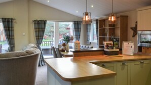 A modern kitchen with a wooden countertop, a built-in island, and a dining area with a sofa and chairs.
