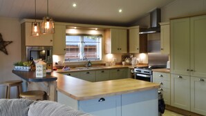 A modern kitchen with a central island, built-in appliances, and pendant lighting.