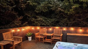 A wooden deck with outdoor seating and a hot tub.