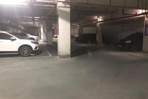 A parking garage with multiple cars parked under concrete pillars. - Shankee Hotel (Xianyou Lizhong Pedestrian Street) (Xianyou)
