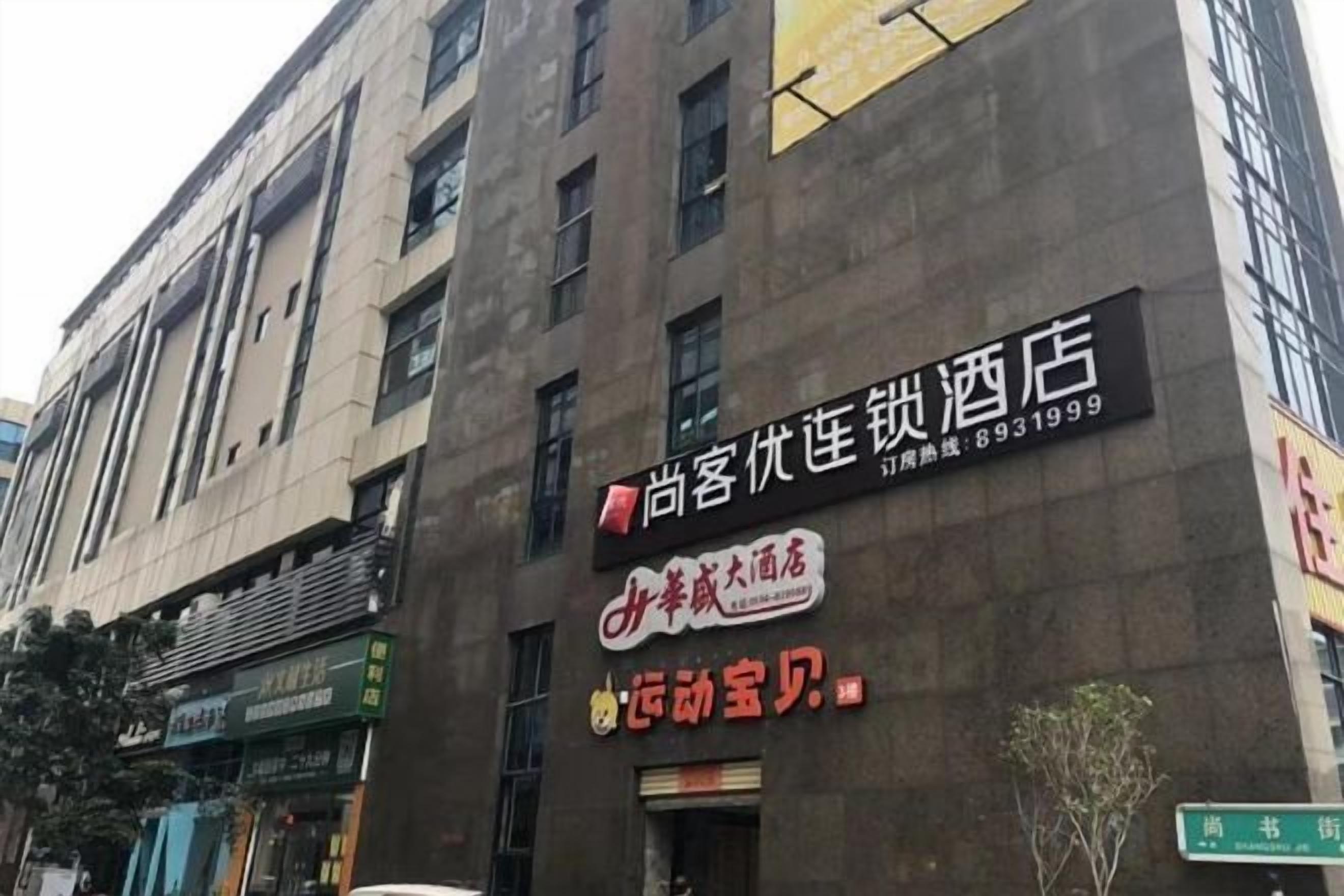 Un edificio con varios letreros, incluyendo uno de hotel y otro de restaurante.