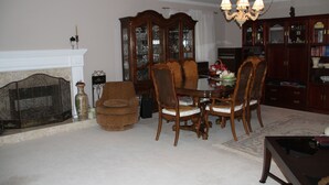 A traditional living room with a fireplace, wooden dining table, and chairs, a bookcase, and a chandelier. -  Large Comfy room w Private bath in gre (Richmond)