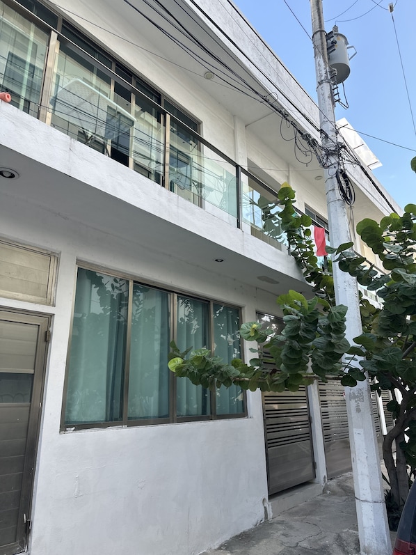 A modern building with large windows, a balcony, and a utility pole with wires.