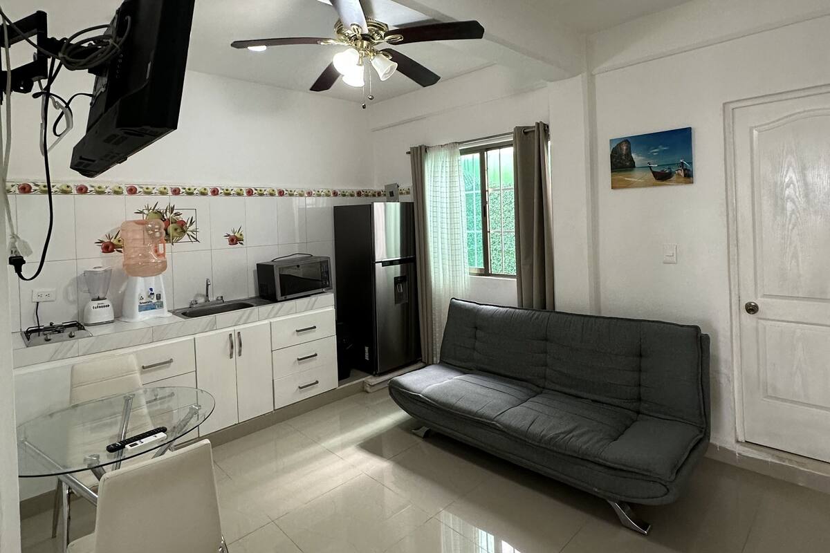 Une cuisine moderne avec un coin repas, un ventilateur de plafond et un canapé.