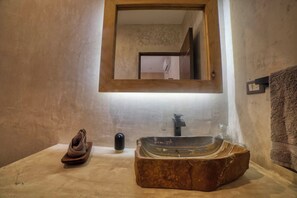 Une salle de bain avec un meuble-lavabo en bois, un miroir, un lavabo et un porte-serviettes.