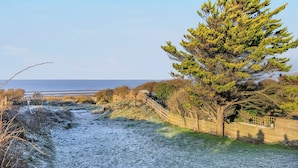 A coastal path with a wooden fence and stairs leading to a beach. - Marram Dune Beach House (Brean)