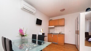 A compact kitchen with wooden cabinets, a microwave, and a built-in oven. - Apartments Barbara With Swimming Pool (Moscenicka Draga)