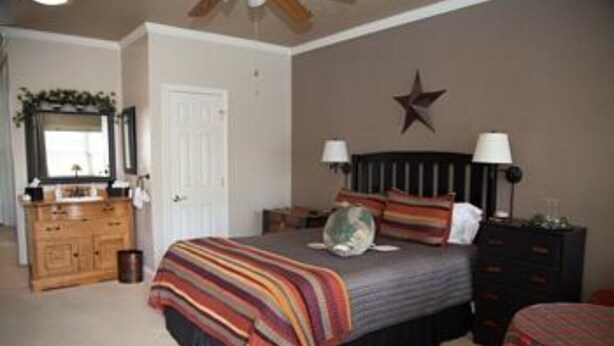Un dormitorio con cama, cómoda y decoración de estrella en la pared.