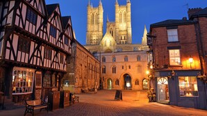 A historic street with traditional half-timbered buildings, a cathedral in the background, and a cobblestone pavement. - 1 bedroom accommodation in Doddington, near Lincoln (Doddington, near Lincoln)