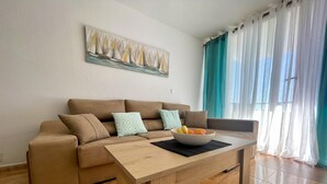 Ein Wohnzimmer mit einer Couch, einem Couchtisch und einem Bild an der Wand.