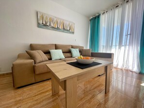 A living room with a sofa, a coffee table, and a painting on the wall.