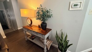 A wooden console table with a mirror, a lamp, and a potted plant. - Beautiful San Antonio Home near SeaWorld/Six Flags (San Antonio)