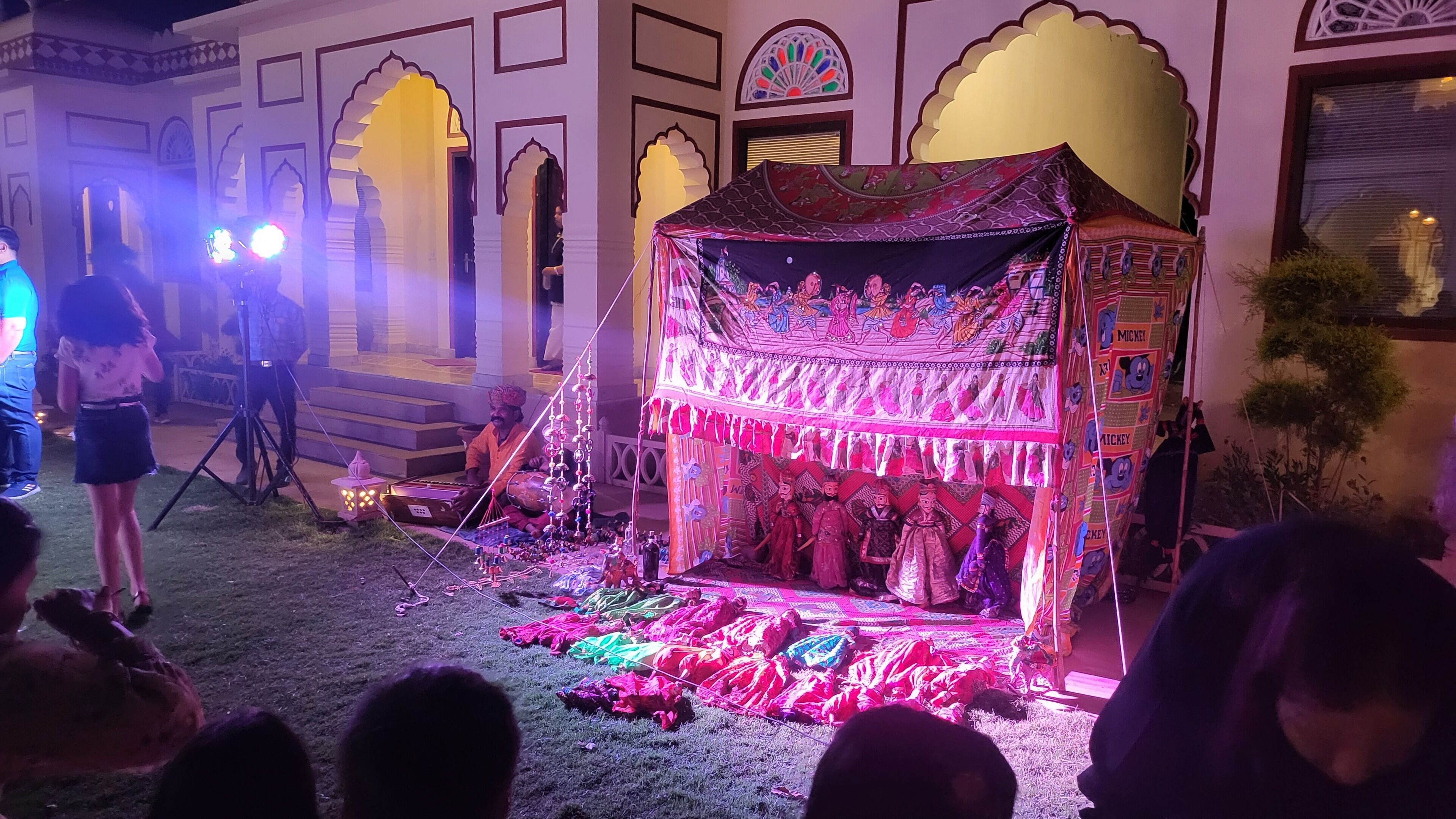 A traditional tent with colorful drapes and a musician playing an instrument.
