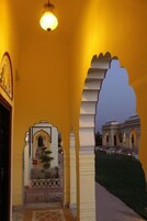 A corridor with arches and a view of a building outside.