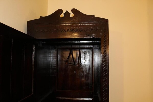 Una puerta de madera oscura con un diseño tallado en la parte superior y un picaporte sencillo.