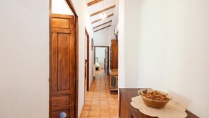 A hallway with wooden doors and a tiled floor leading to a room. - La Casa de Aulabar Belmez de la Moraleda by Ruralidays (Jaén)