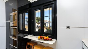 A kitchen with a window, a fruit bowl, and a stool. - Villa Rural el Mirador Álora by Ruralidays (Málaga)