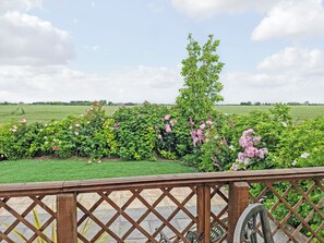 A garden with various flowering plants and a wooden fence.