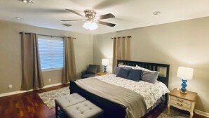 A bedroom with a bed, two bedside tables, a ceiling fan, and a window with curtains. - Comfortable home in the heart of Conroe, Texas and minutes away from Lake Conroe (Conroe)