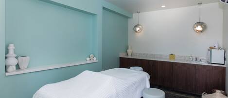 Un cuarto de spa con dos camas, un lavabo y un tocador.