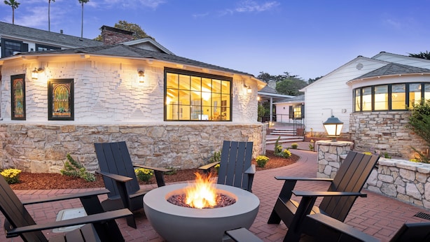 A stone building with a fire pit and outdoor seating.