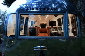 Una caravana vintage con kitchenette, una cama y un pequeño comedor.