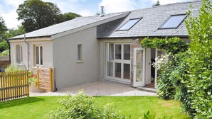 A modern house with a sloped roof, large windows, and a well-maintained garden. - 2 bedroom accommodation in Valast Hill, near Stackpole (Valast Hill, near Stackpole)