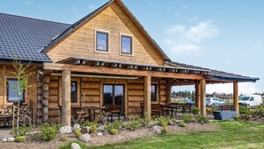 A log cabin with a covered porch and outdoor seating. - 2 bedroom awesome apartment in Jezierzany (Jezierzany)