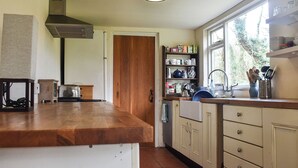A kitchen with wooden countertops, a built-in stove, and a window providing natural light.