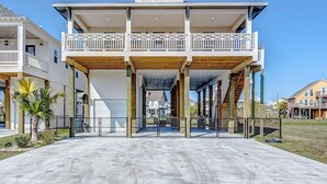 Un bâtiment à deux étages doté d’un balcon, d’un espace couvert et d’un trottoir en béton.