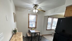 A compact kitchen with a wooden countertop, a dining table, a ceiling fan, and a black refrigerator. - Chic & Cozy APT-Self Check-In (Appleton)