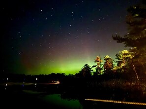 Un ciel nocturne parsemé d’étoiles et illuminé par des aurores boréales.