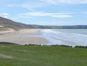 A coastal beach with a grassy foreground, a sandy beach, and a view of the sea. - 2 bedroom accommodation in Instow, near Bideford (Instow, near Bideford)