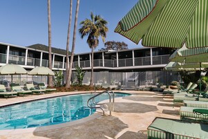 Una piscina al aire libre, sombrillas, tumbonas