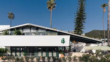 Experience the sleek, contemporary design of this hotel, featuring a flat roof and spacious outdoor seating area.