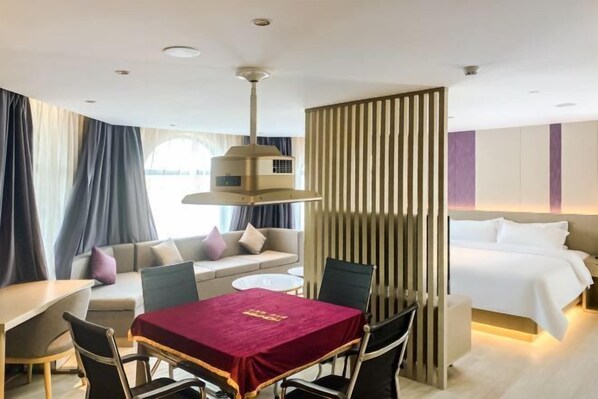 A hotel room with a dining table, a sofa, a bed, and a partition wall. - Lavande Hotel Dongguan Xiegang Branch (Dongguan)