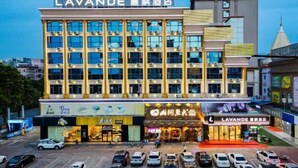 A hotel with a prominent sign reading "LAVANDE" and multiple storefronts below. - Lavande Hotels (Dongguan)