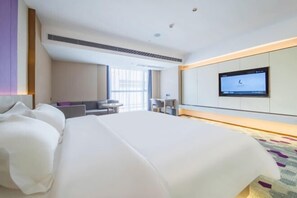 A hotel room with a large bed, a TV mounted on the wall, and a desk with a chair. - Lavande Hotel Dongguan Xiegang Branch (Dongguan)