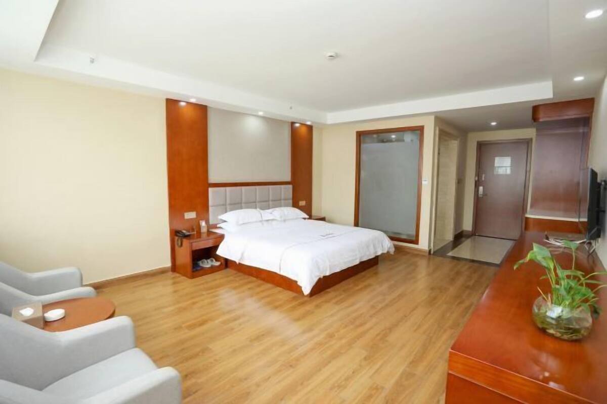 Una habitación de hotel con cama, mesita de noche, silla y televisión.