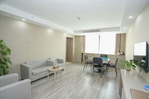 Una sala moderna con sofá, mesa de centro y comedor con sillas.