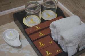 Una bandeja con frascos, un zapato blanco y toallas dobladas.