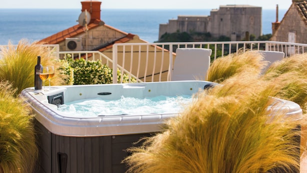 Un jacuzzi avec vue sur la mer et les bâtiments en arrière-plan.