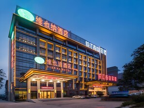 Un hôtel à plusieurs étages, reconnaissable à son enseigne bien visible indiquant « Vienna Hotel ».