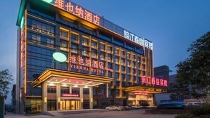 A multi-story hotel with illuminated signage, a prominent entrance, and a parking area. - Vienna Hotel (Feidong Dongcheng High-speed Railway Station) (Feidong)