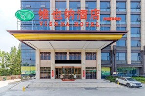A hotel entrance with a modern facade, large glass windows, and a prominent sign.