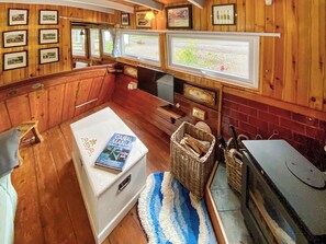 A cabin with wooden walls, a white refrigerator, a television, a fireplace, and framed pictures on the wall. - The Prince - UK42204 (Glendaruel)