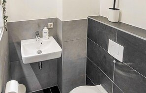 A bathroom with a white sink, a mirror, and a toilet. - Beautiful home in Den Oever with WiFi (Den Oever)