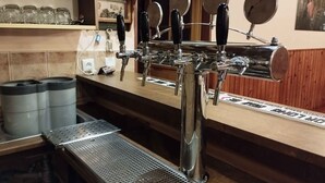 Un bar doté de plusieurs robinets et d’un comptoir en métal.