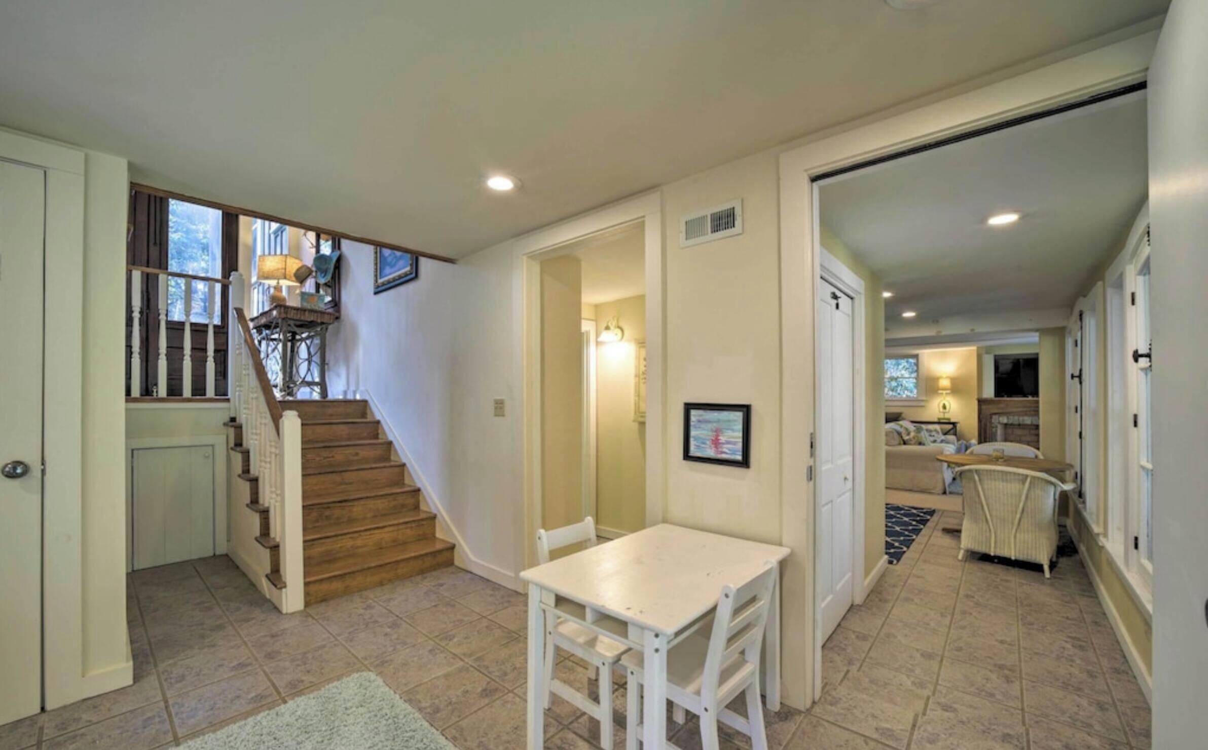 A spacious living area with a staircase, a dining table, and a cozy seating area.