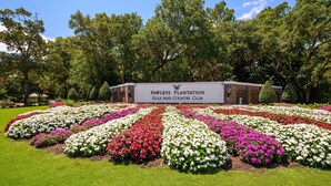 Pawleys Plantation Golf and Country Club entrance with a sign, surrounded by well-maintained flower beds and trees. - 3BR/3BA Ground Level ,Gated Pawleys Plantation (Pawleys Island)